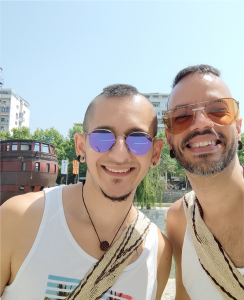 This is a photo of us, the Queer Nomad Boys, Andy and Feli. In the background there is a monument that looks like a sea ship, this is located in Skopje North Macedonia. 